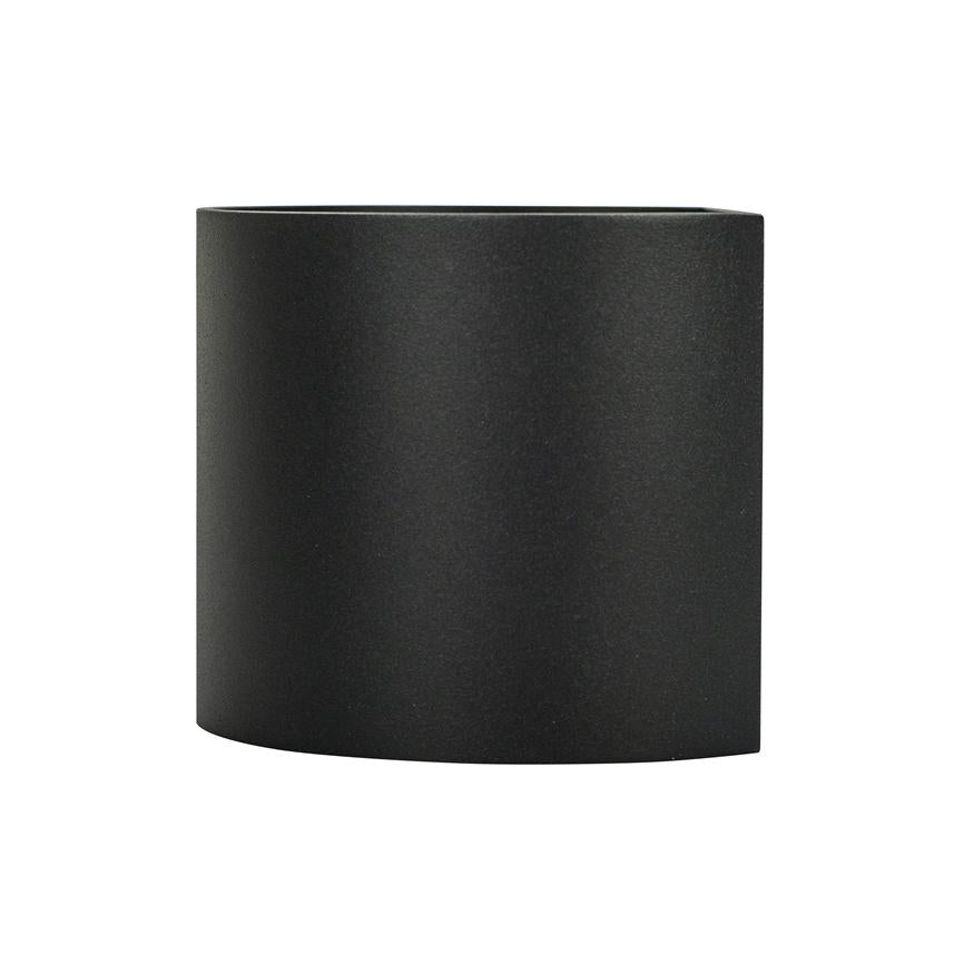 Sort halvcylindrisk objekt står centralt mod en hvid baggrund; matte, glatte sider og åben top, fremstår som en kort cylinder eller lyskappe.