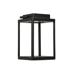 Sort, kubeformet metalarmatur lyser nedad fra en indvendig lyskilde; åben ramme med fire søjler, isoleret på en hvid studiebaggrund.