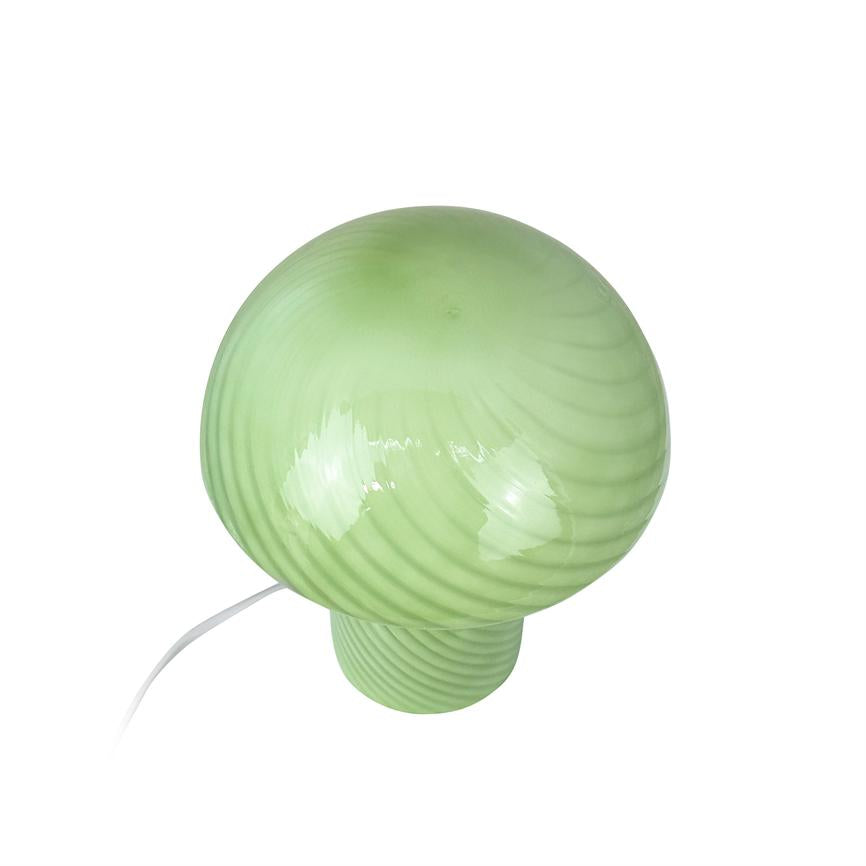 Grøn, blank svampeformet bordlampe med spiralstriber; den er tilsluttet med hvid ledning og står på en neutral hvid baggrund.