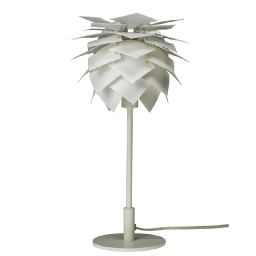 Bordlampe formet som ananas af overlappende hvide plader, der omslutter pæren; den står på en slank stang og rund fod med kabel på hvid baggrund.