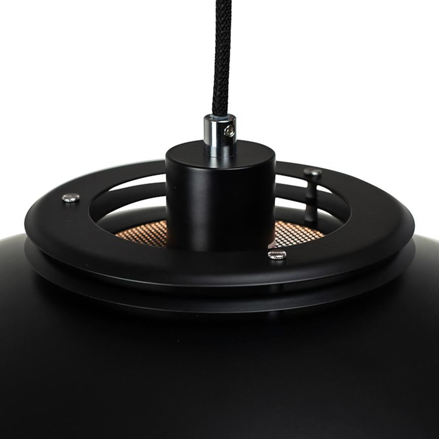 Sort pendellampe hænger i en sort flettet ledning; en cylindrisk metalholder forbinder lampekuplen med ringformede ventilationsåbninger, synligt kobberfarvet net inderst, mod en neutral hvid baggrund.