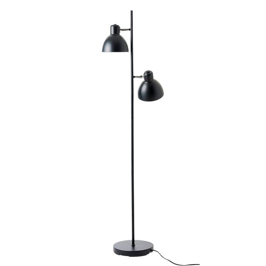 Sort metal gulvlampe med to justerbare skærme monteret på en slank stang over rund fod; skærmene peger nedad og skråt, placeret på hvid studiebaggrund, ledning synlig.