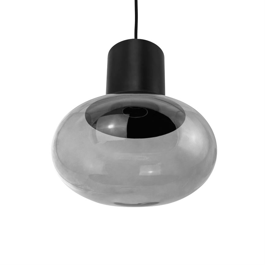 En rund, røgfarvet glaspendel hænger i en sort ledning med en sort, cylindrisk fatning; lampeskærmen er blank og reflekterende mod en neutral hvid baggrund.