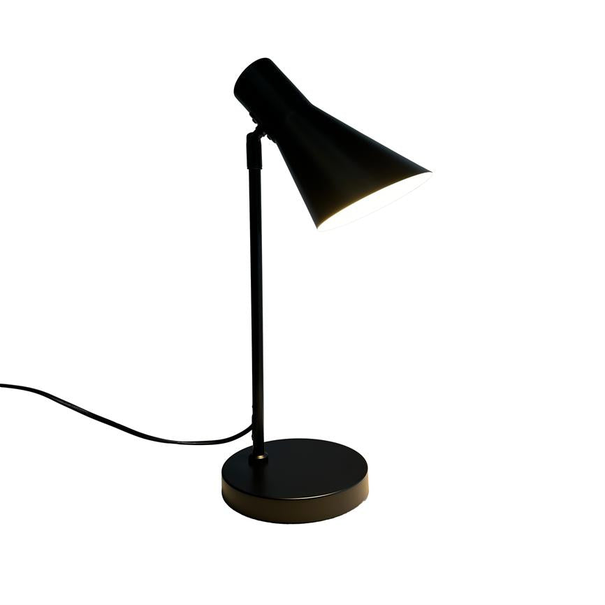 Skrivebordslampe står skævt vinklet; konisk sort skærm lyser nedad. Slank sort stang på rund base med ledning, isoleret mod en ensartet hvid baggrund.