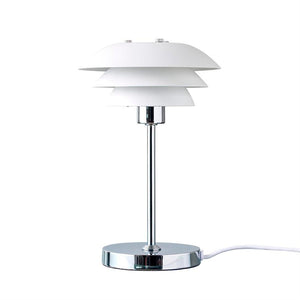 Bordlampe med tre lagdelte, hvide skærme, monteret på slank kromstang og rund kromfod; den står oprejst og er sluttet til en hvid ledning mod en ensartet hvid baggrund.