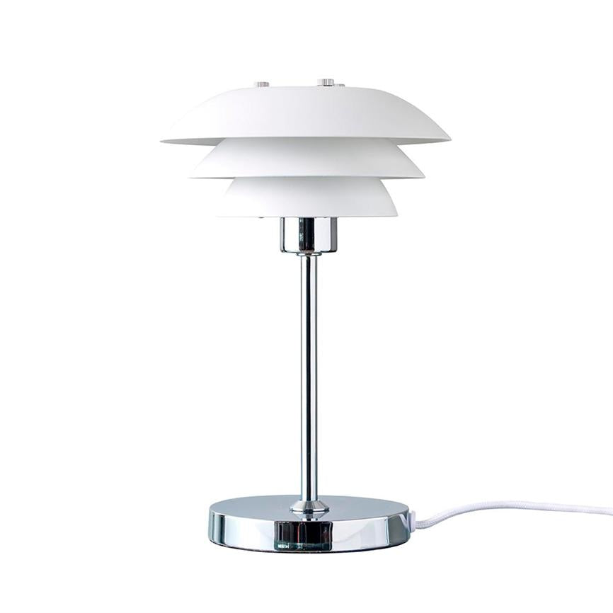 Bordlampe med tre lagdelte, hvide skærme, monteret på slank kromstang og rund kromfod; den står oprejst og er sluttet til en hvid ledning mod en ensartet hvid baggrund.
