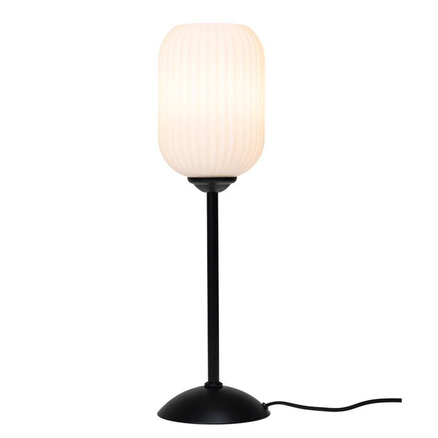 Bordlampe med oplyst, ribbet oval hvid skærm; sort slank skaft og rund sort fod, strømkabel fører ud til siden på neutral hvid baggrund.