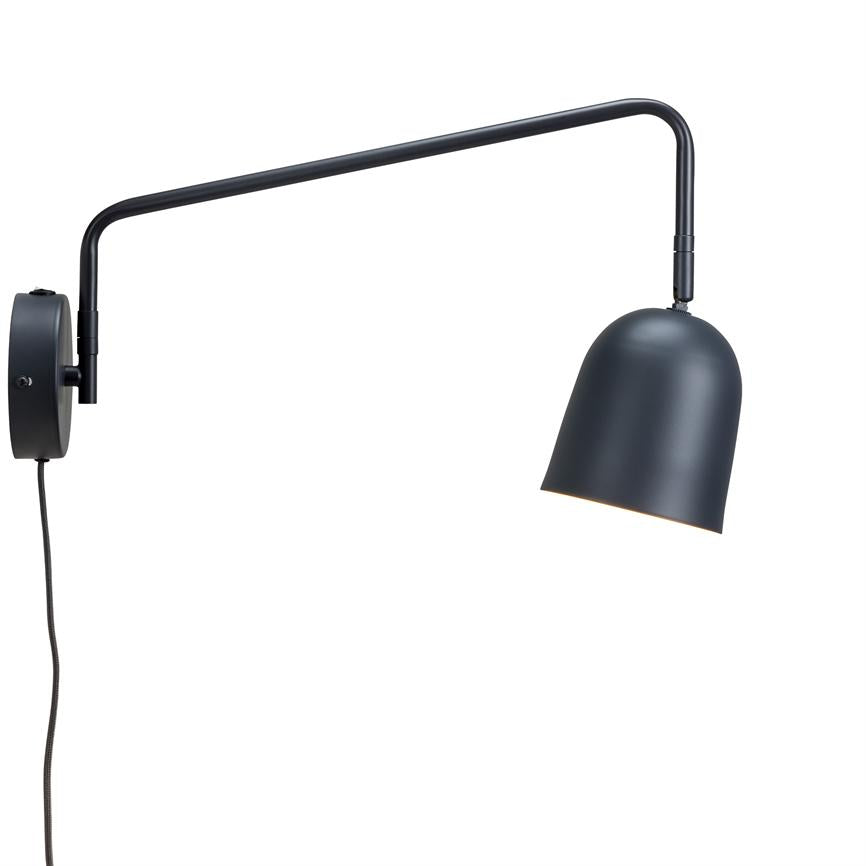 Sort væglampe med lang, bøjelig arm holder en svagt oplyst, nedadvendt buet lampeskærm mod en ensartet hvid baggrund.