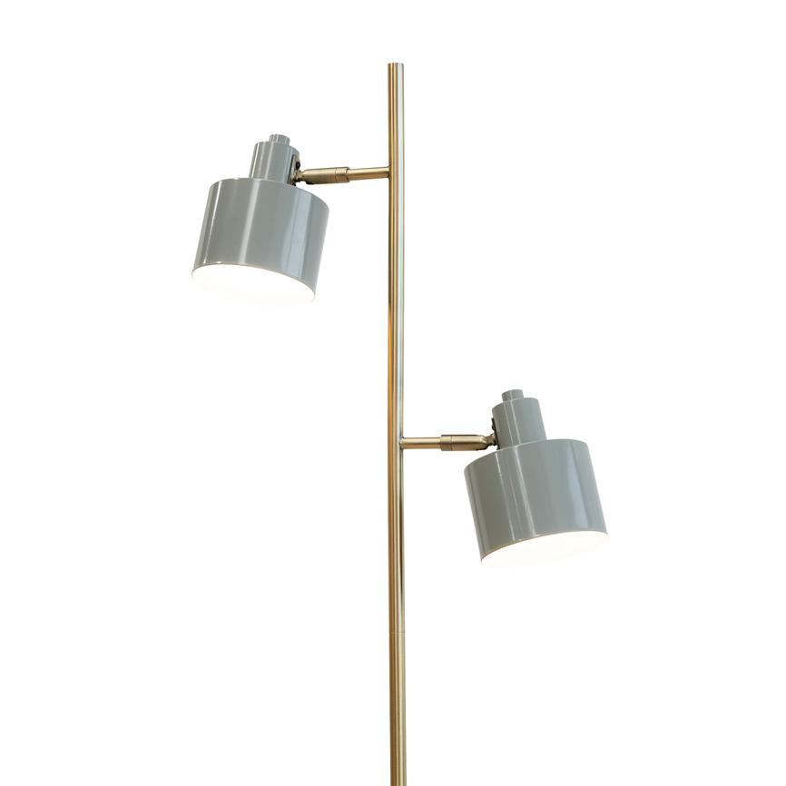Standerlampe med to grå metalskærme monteret på en slank, gylden metalkolonne; de justerbare skærme er tændte og peger nedad mod en neutral, hvid baggrund.