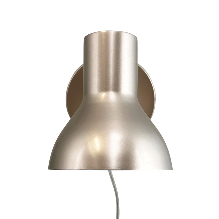 Metal væglampe monteret på en rund vægplade, lampeskærmen peger nedad og reflekterer blødt lys; en ledning hænger ned fra bunden; enkel, hvid baggrund.