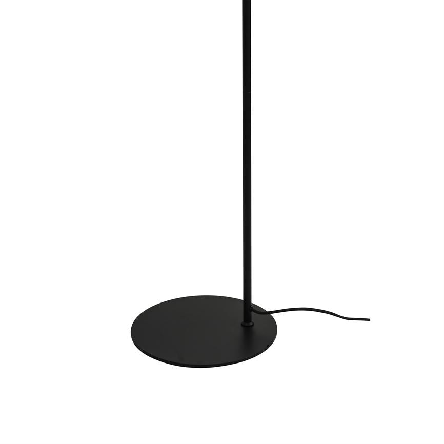 Sort gulvlampe står med en tynd, lodret stang monteret i en rund, flad fod; en sort netledning løber ud til siden på hvid baggrund.