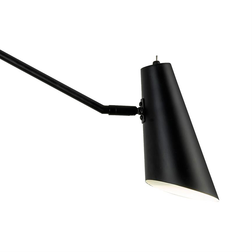 Sort konisk lampe peger lys nedad fra en lang, tynd arm i en ren, hvid baggrund.