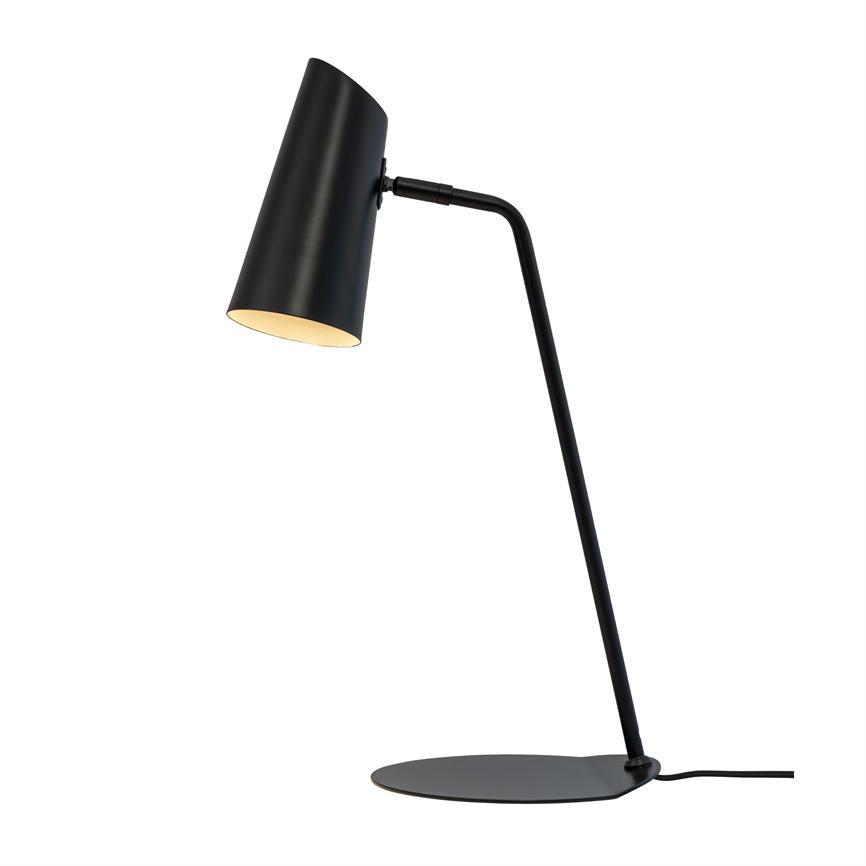 Sort bordlampe med skråtstillet cylindrisk skærm, lyser nedad; slank vinklet stang monteret på lav rund metalbase med synlig ledning, placeret mod en ensartet hvid baggrund.