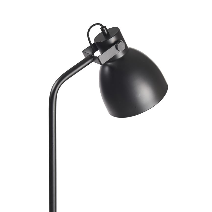 Sort metal gulvlampe peger skråt nedad med bøjlet skaft og afrundet skærm; mat sort finish, justerbar hængsel og synlig ledning, vist isoleret på hvid baggrund.