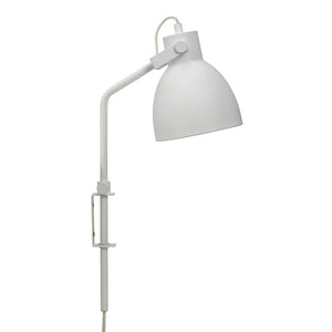 Hvid klemme-væglampe med rund, skåleformet skærm; arm bøjet i en ret vinkel, skærmen peger nedad mod en ensartet hvid baggrund, med klemme og synlig ledning.