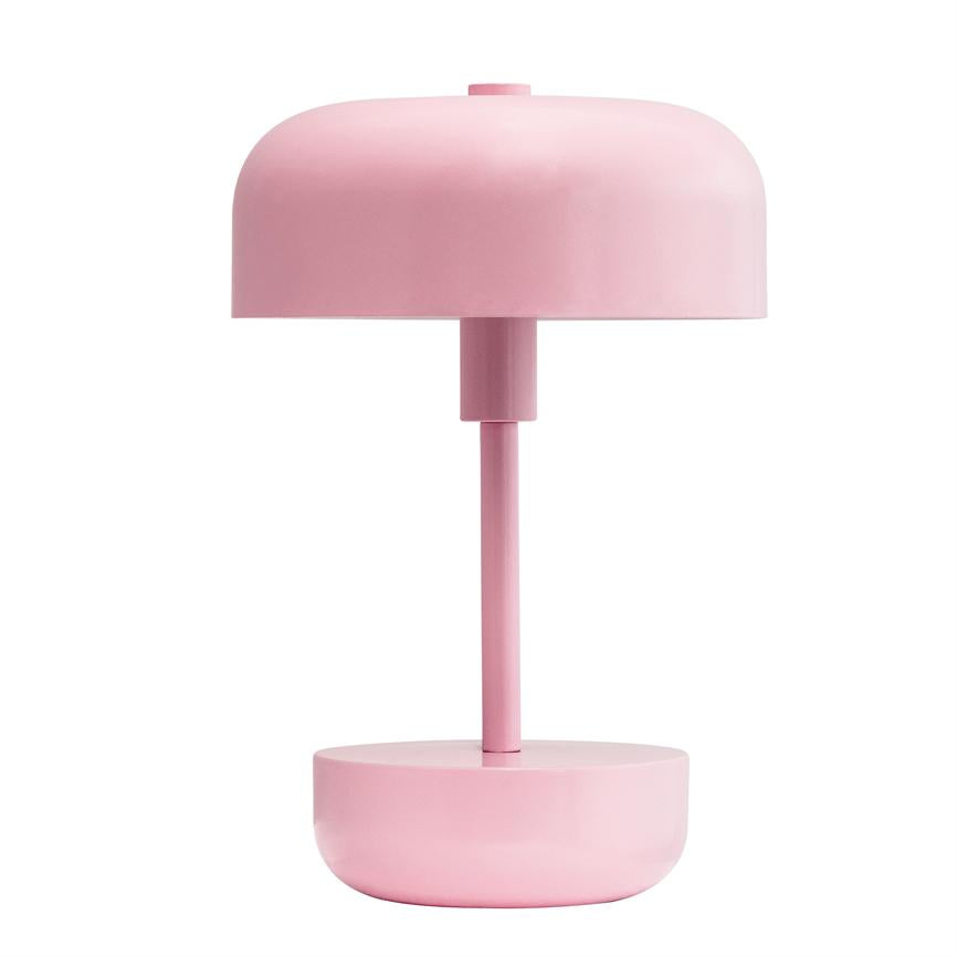 Bordlampe står lodret; har cylindrisk stang, afrundet skærm og skålformet base i ensartet lyserød; placeret mod neutral hvid baggrund.