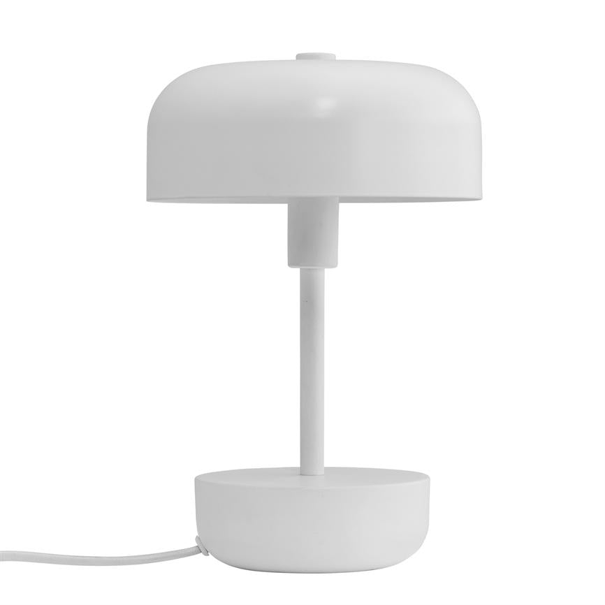Hvid rund bordlampe står på en enkel rund fod; en tynd søjle bærer en halvkugleformet skærm, afbildet mod en ensartet hvid baggrund med synlig ledning.