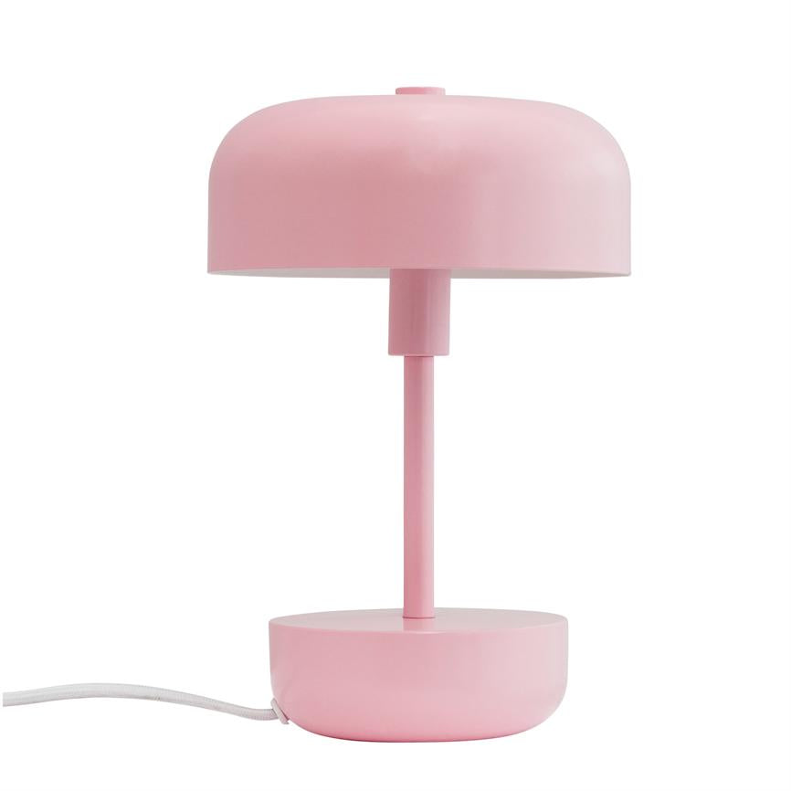 En mat lyserød bordlampe står opret; rund skærm over en smal stang og rund base, placeret mod en ensartet hvid baggrund.