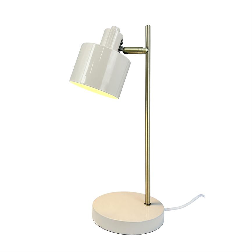 Bordlampe med hvid, cylinderformet skærm monteret på en tynd messingfarvet stang; skærmen er vinklet og kaster varm, nedadrettet lys over en rund hvid bund på neutral hvid baggrund.