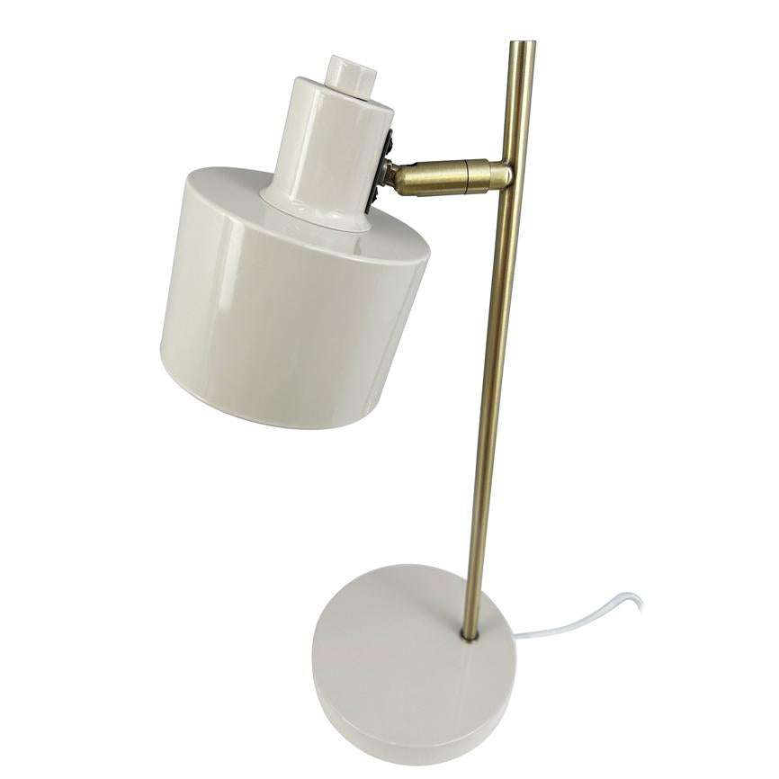 Skrivebordslampe med hvid cylindrisk skærm, vinklet nedad; skærmen sidder på en justerbar messingstang over rund hvid base; hvid ledning ligger ved basen på hvid baggrund.