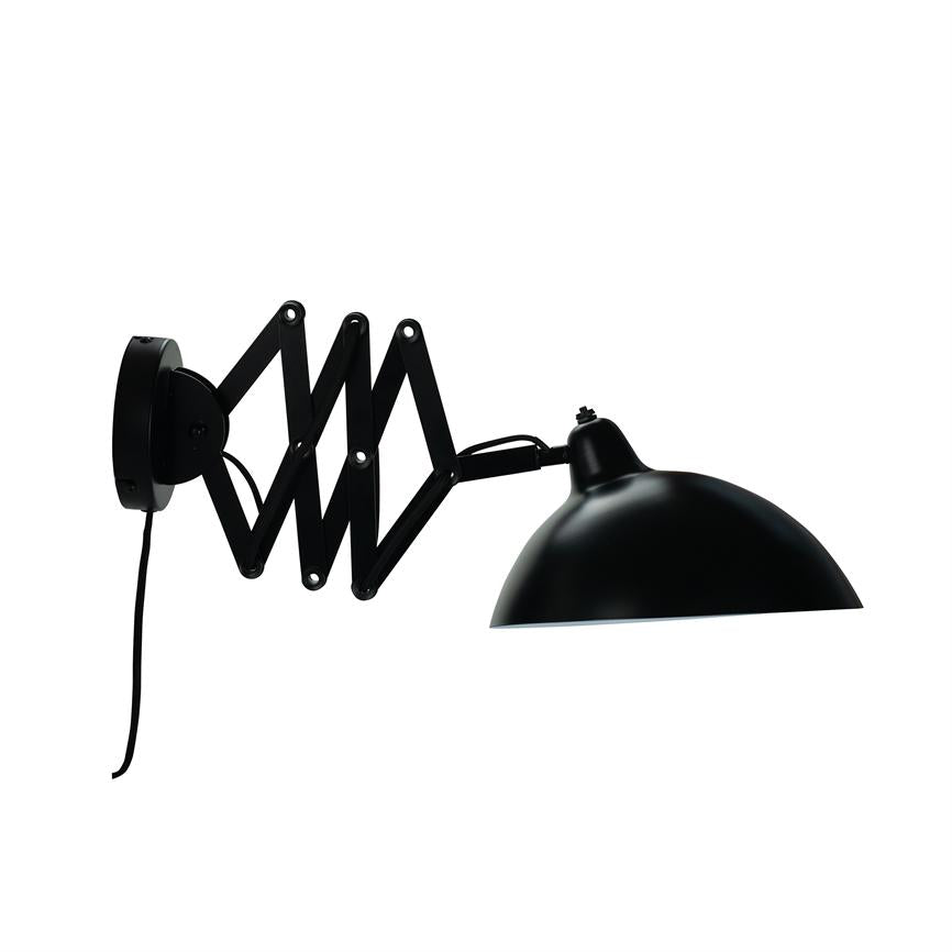Væglampe med saksearm folder sig ud og bærer en sort halvkugleformet skærm; monteret på rundt vægbeslag med sort ledning hængende ned foran hvid baggrund.