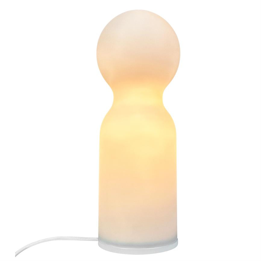 Lampe udsender en varm, gylden glød fra en rund top og cylindrisk krop, står på hvid baggrund med hvid ledning synlig ved basen.