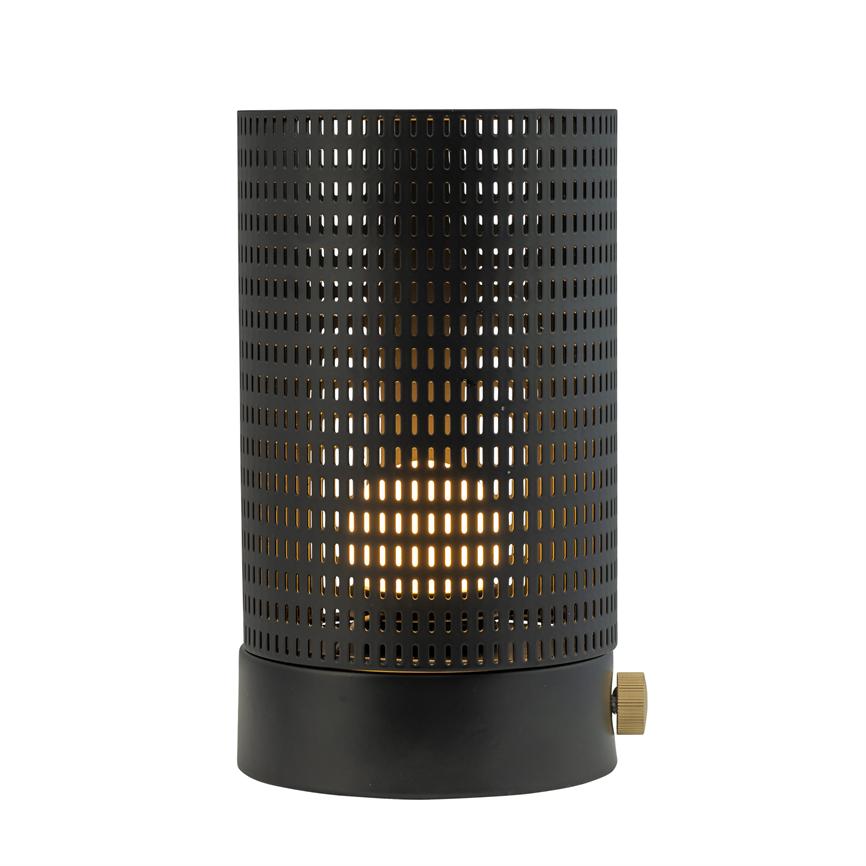 Cylindrisk sort bordlampe udsender varmt, diffust lys gennem et perforeret metalgitter og står på en hvid, neutral baggrund.