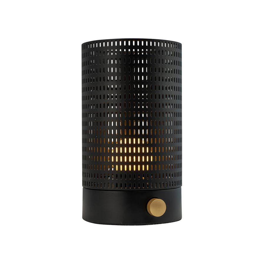Cylindrisk sort metalbordlampe med perforeret skærm, udsender varmt gyldent lys gennem små rektangulære huller; sort rund base med guldfarvet drejeknap, neutral hvid baggrund.