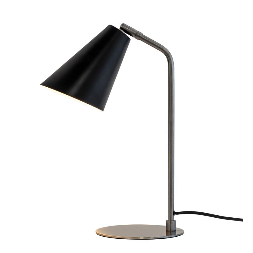 Bordlampe med sort konisk skærm, står tændt og nedadrettet på slank metalfod med rund base mod en hvid baggrund.