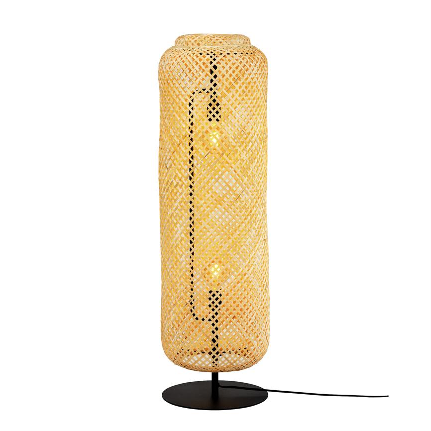 Høj cylindrisk flettet rattanlampe udsender varm, gylden glød; to synlige glødende pærer i sort metalfod med ledning, placeret foran en hvid baggrund.