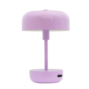 Bordlampe i lys lilla står oprejst på en tynd central stang, med rund kuppel-formet skærm og rund base; enkel, modernistisk design på ensartet hvid baggrund.