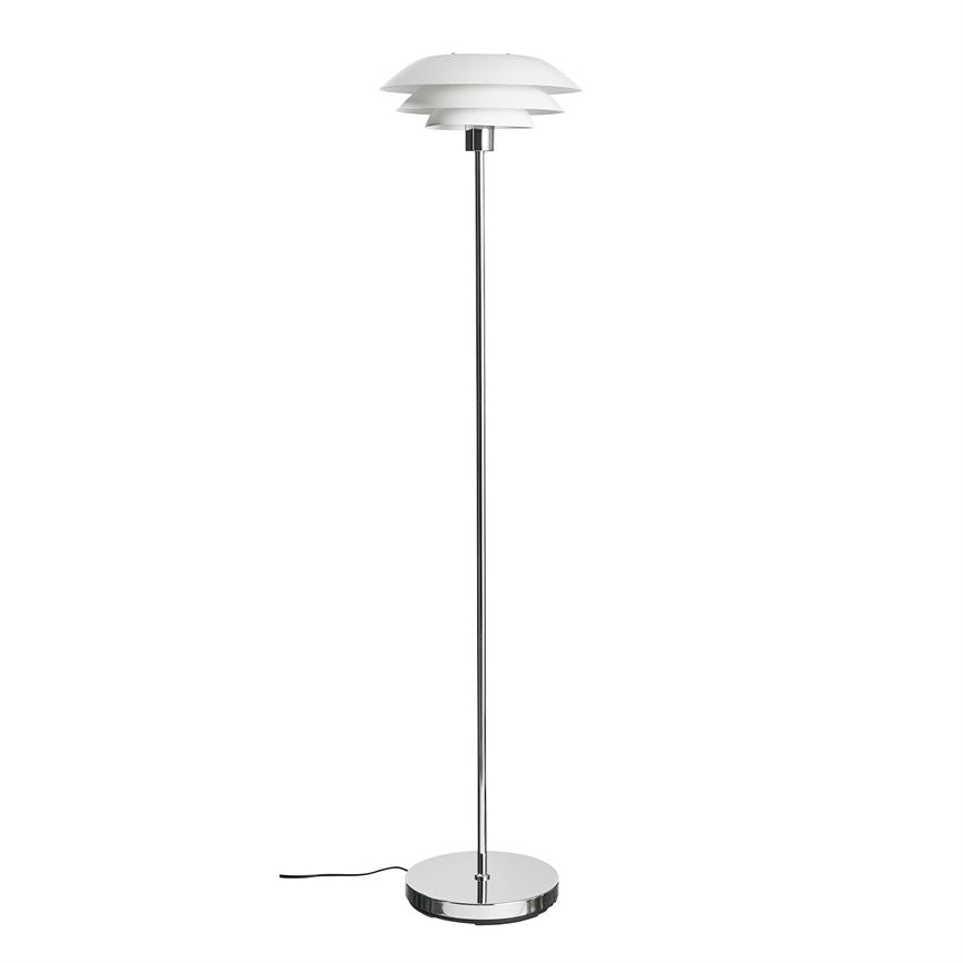 Gulvlampe står oprejst med tredelt hvid skærm, slank kromstang og rund krom fod på hvid baggrund; sort ledning ligger løst ved basen.