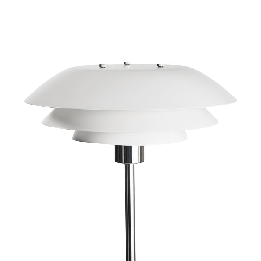 Hvid, lagdelt standerlampe afskærmer og diffuserer lys med tre flade, cirkulære skærme; monteret på en poleret kromstang, præsenteret mod en ensartet hvid baggrund.
