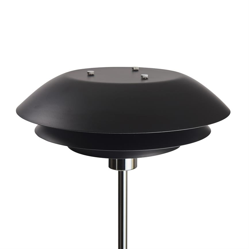 Sort, flerlags, skiveformet lampe monteret på en slank kromstang; lampekopperne er stablet som en skive med tre små skruer på toppen, skaber et nedadrettet, skjult lys; hvid studiobaggrund.