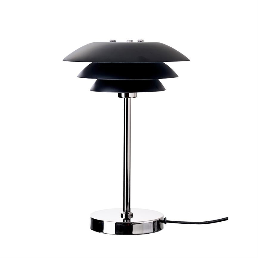 Bordlampe med tre lagdelte, sorte skærme står på en kromstang; rund kromfod og sort ledning til højre på neutral hvid baggrund.