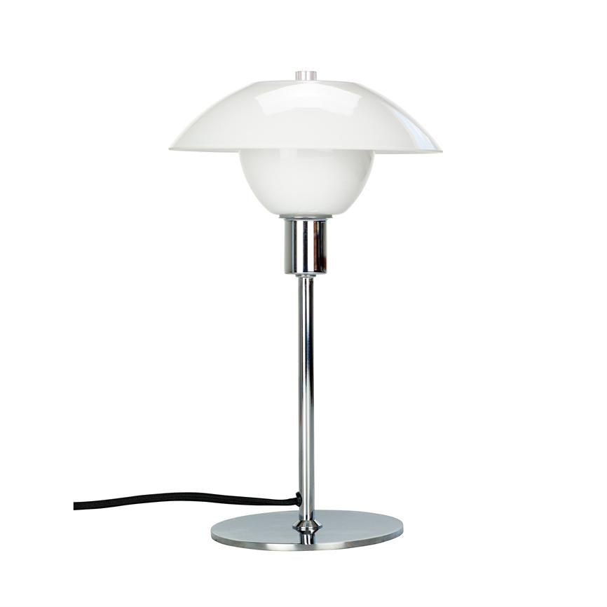 Bordlampe med rund, hvid skærm og kromstamme; står lodret på en rund kromfod, sort ledning løber ud til venstre; isoleret mod en ensartet hvid baggrund.