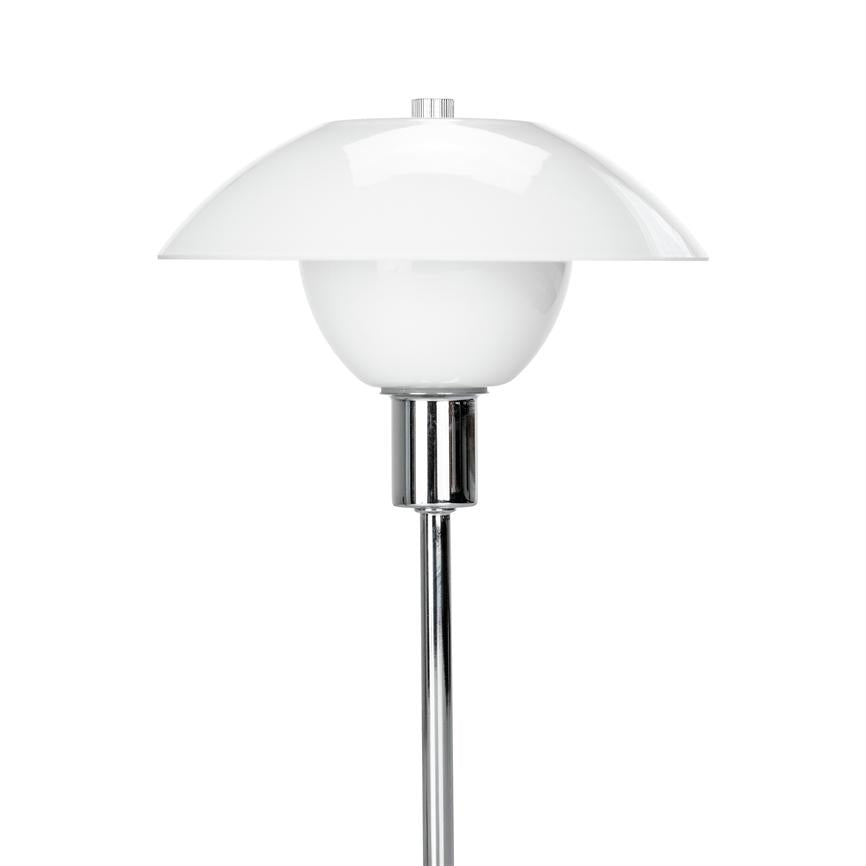 Hvid bordlampe med to-delt rund skærm hviler på en slank kromstang, lyset skjult under den buede skærm; enkel, moderne form mod en ensartet hvid baggrund.