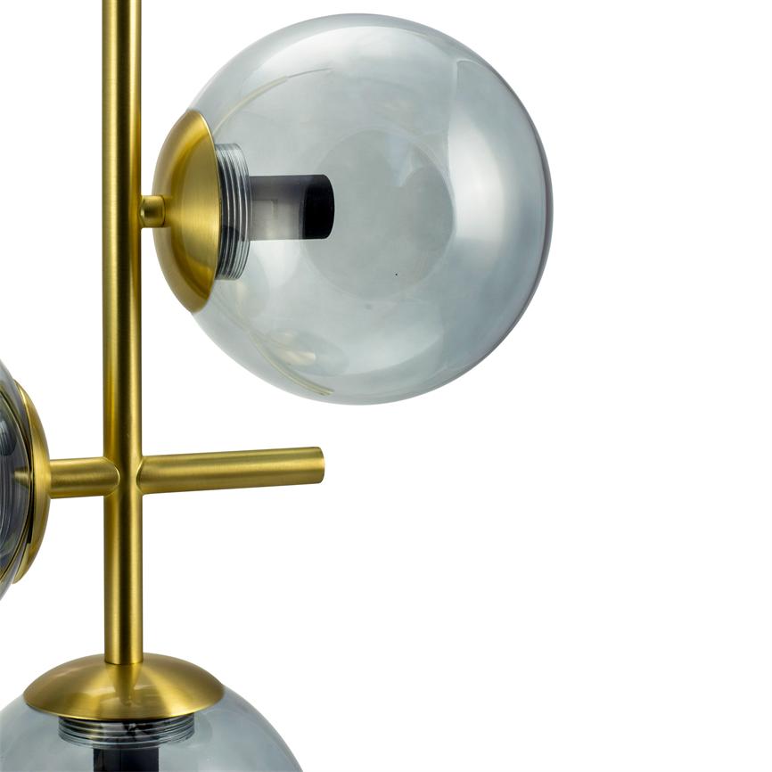 Røgfarvet glasglobus monteret på en lodret messingstang; glasskålen sidder i en guldtonet fatning og reflekterer lys, foran en neutral hvid baggrund.