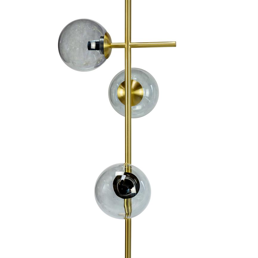 Moderne lampe med tre klare glaskupler monteret langs en lodret messingstang; kuplerne indeholder sorte og gyldne fatninger og er placeret forskudt mod hvid baggrund.