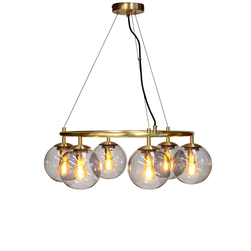 En gylden loftlampe med seks klare glaskupler, hængende i sorte kabler fra en messingring, som udsender varm, gylden glød mod en neutral hvid baggrund.