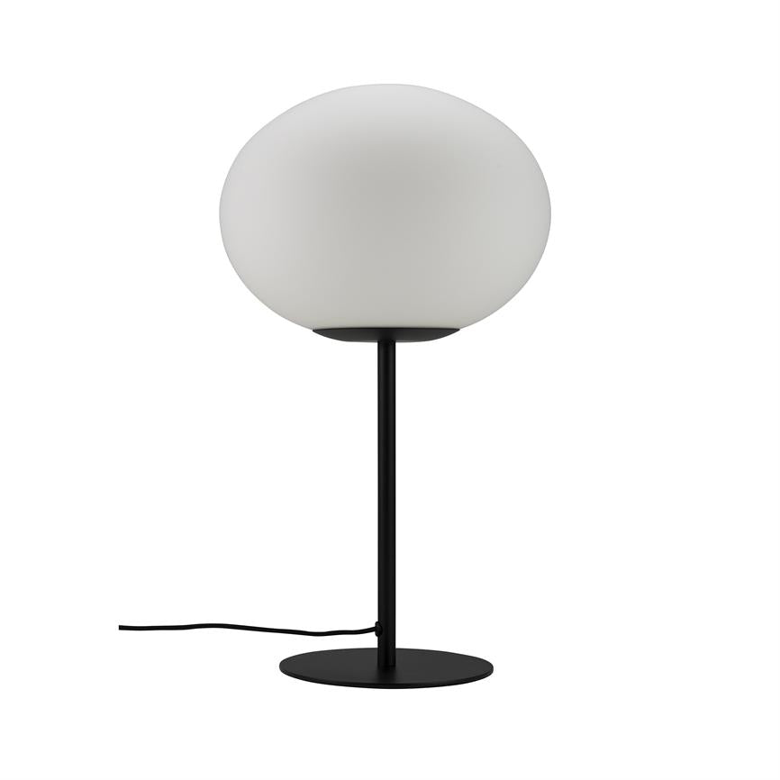 En bordlampe med rund, mat hvid glaskuppel hviler på en tynd sort stang, monteret på en flad rund sort fod; en sort ledning ligger på en hvid baggrund.