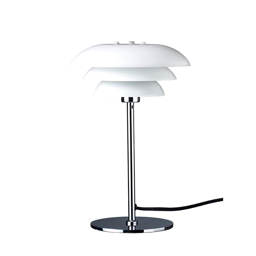 Bordlampe står på en rund kromfod, støttet af en slank kromstang; tre lagdelte hvide lampeskærme øverst; sort ledning fører ud til højre på hvid baggrund.