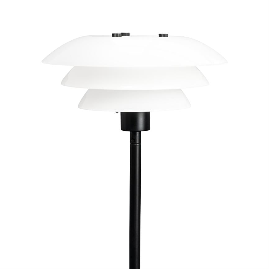 Gulvlampe står med tre hvide, skålformede skærme stablet i lag; de omslutter lyskilden over en slank sort metalstang foran en neutral hvid baggrund.