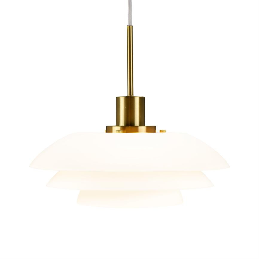 En hvid, flerlags pendel hænger i en guldfarvet metalfatning og udsender blødt, diffust lys; enkel, moderne lampe mod en ensartet hvid baggrund.