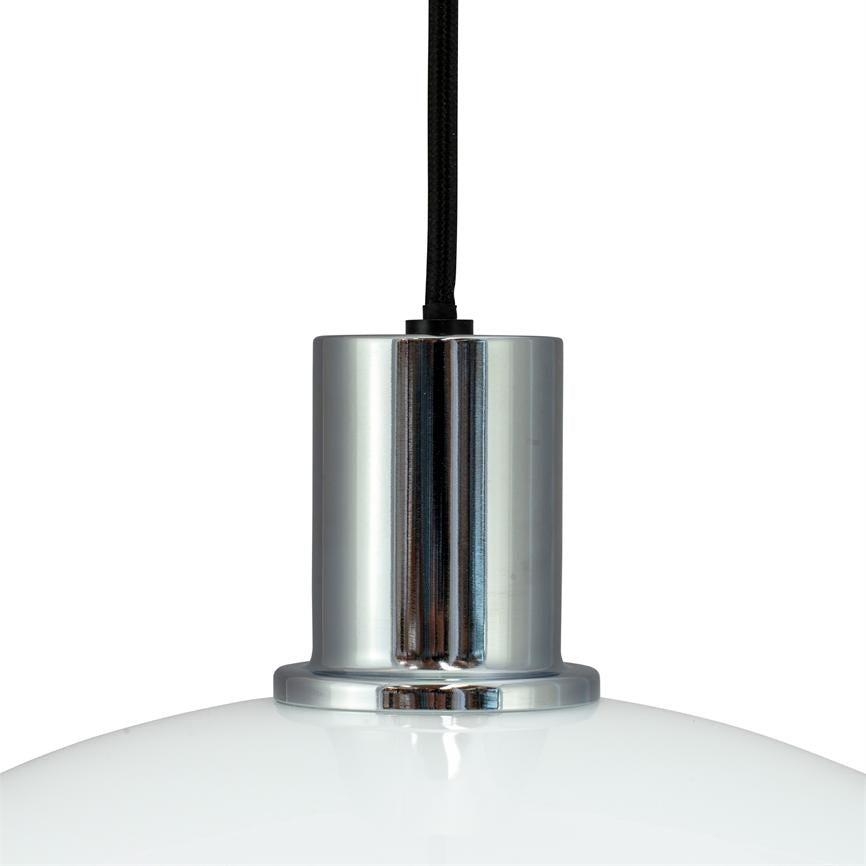 Pendellampe hænger fra en sort stofledning; krom cylindrisk fatning holder en hvid, blank glaskuppel; enkel, neutral hvid baggrund uden andre elementer.