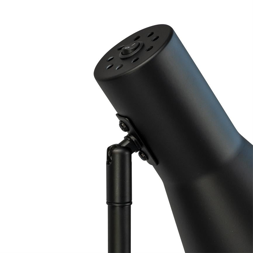 Sort metal lampehoved hælder fremad, forbundet til en slank arm via et justerbart hængsel; øverst ventilationshuller og en rund tænd/sluk-knap; hvid baggrund.