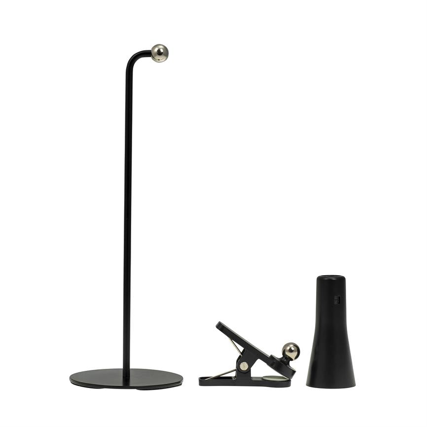 Sort høj stander står med rund bund og lille sølvkugle øverst; en sort metalclips ligger halvåben med sølvkugle; en sort konisk holder står ved siden af, på hvid baggrund.
