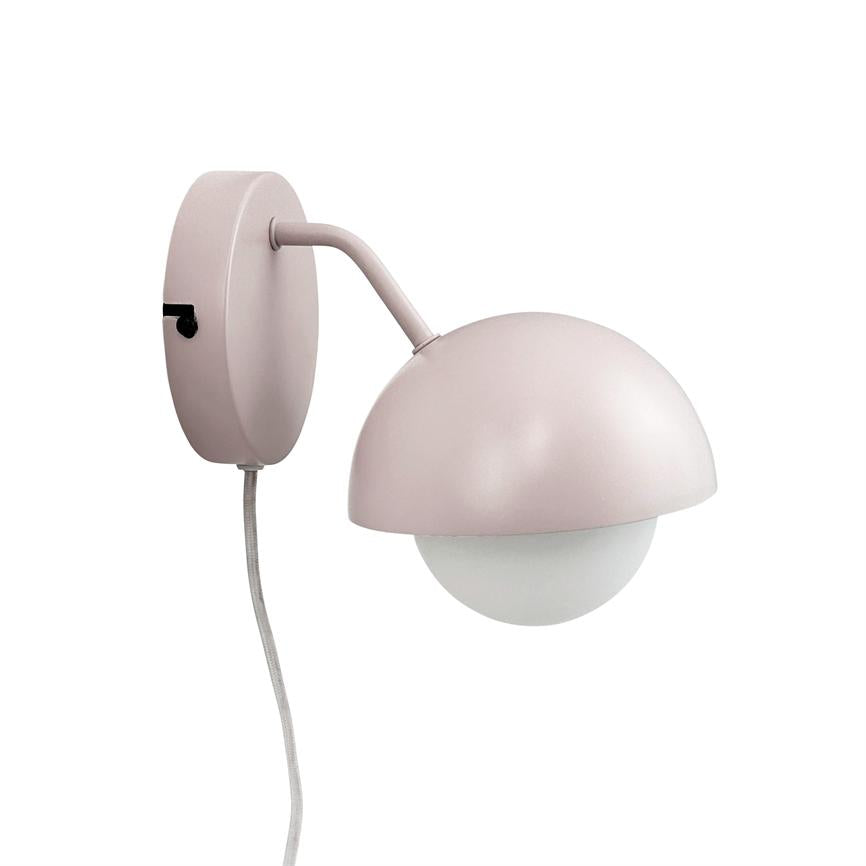 Væglampe med lyserød mat halvskærm, der omslutter en hvid rund pære; arm buer fra en rund vægplade, med synlig stofkabel og sort afbryder.