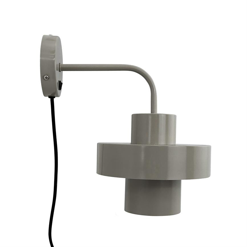 Væglampe med cylindrisk, to-niveau skærm hænger fra en buet arm; en sort ledning løber ned fra den runde montageroset mod en neutral hvid baggrund.