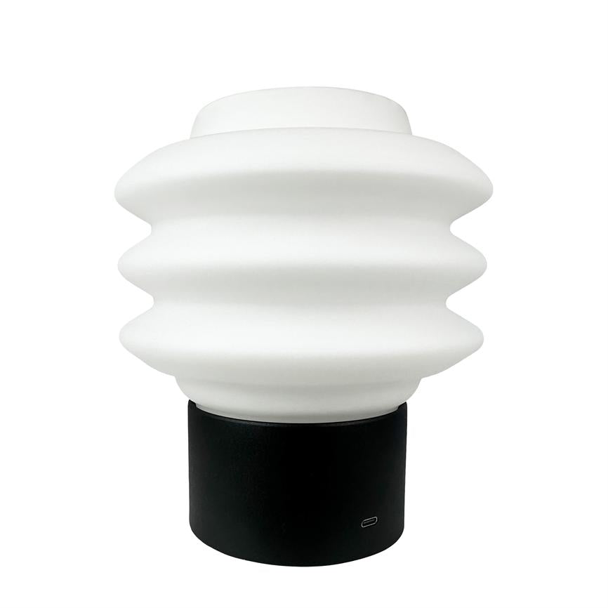 Bølgeformet hvid lampe sidder på en sort cylindrisk base foran en neutral hvid baggrund. Tekst/ikon ved basen: "USB‑C".